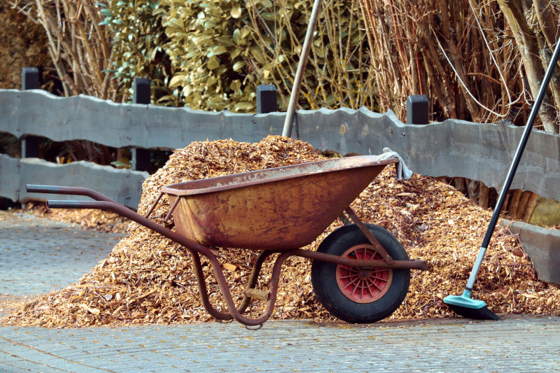 Eine Schubkarre wird mit Rindenmulch befüllt