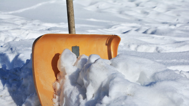 Schnee mit der Schneeschaufel schippen