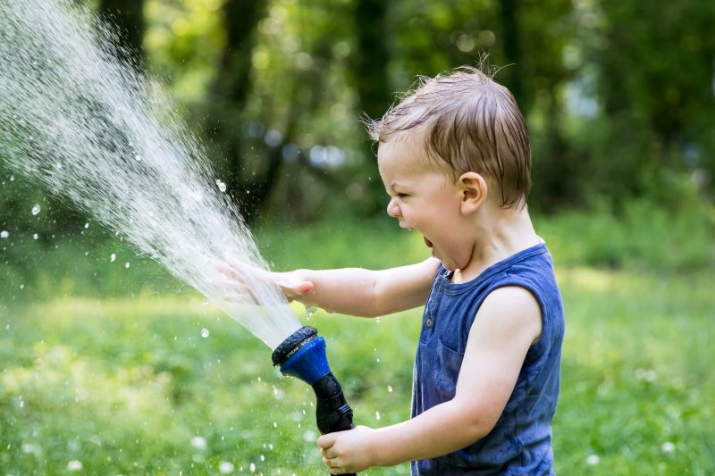 Nasse Abkühlung bei heißen Sommertagen mit dem Gartenschlauch