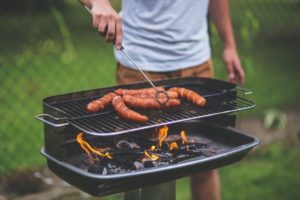 Mann grillt mit einem Säulengrill