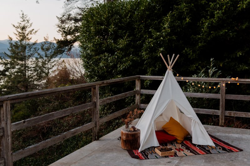 Ein Outdoor Teppich auf einer Terrasse unter einem Indianerzelt